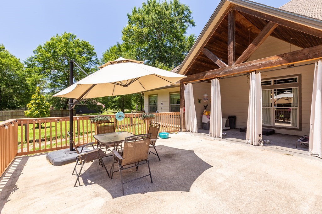 1171 Old Ewing Road Lufkin, TX 75901 - Photo 31 of 49 a patio with a table and chairs under an umbrella