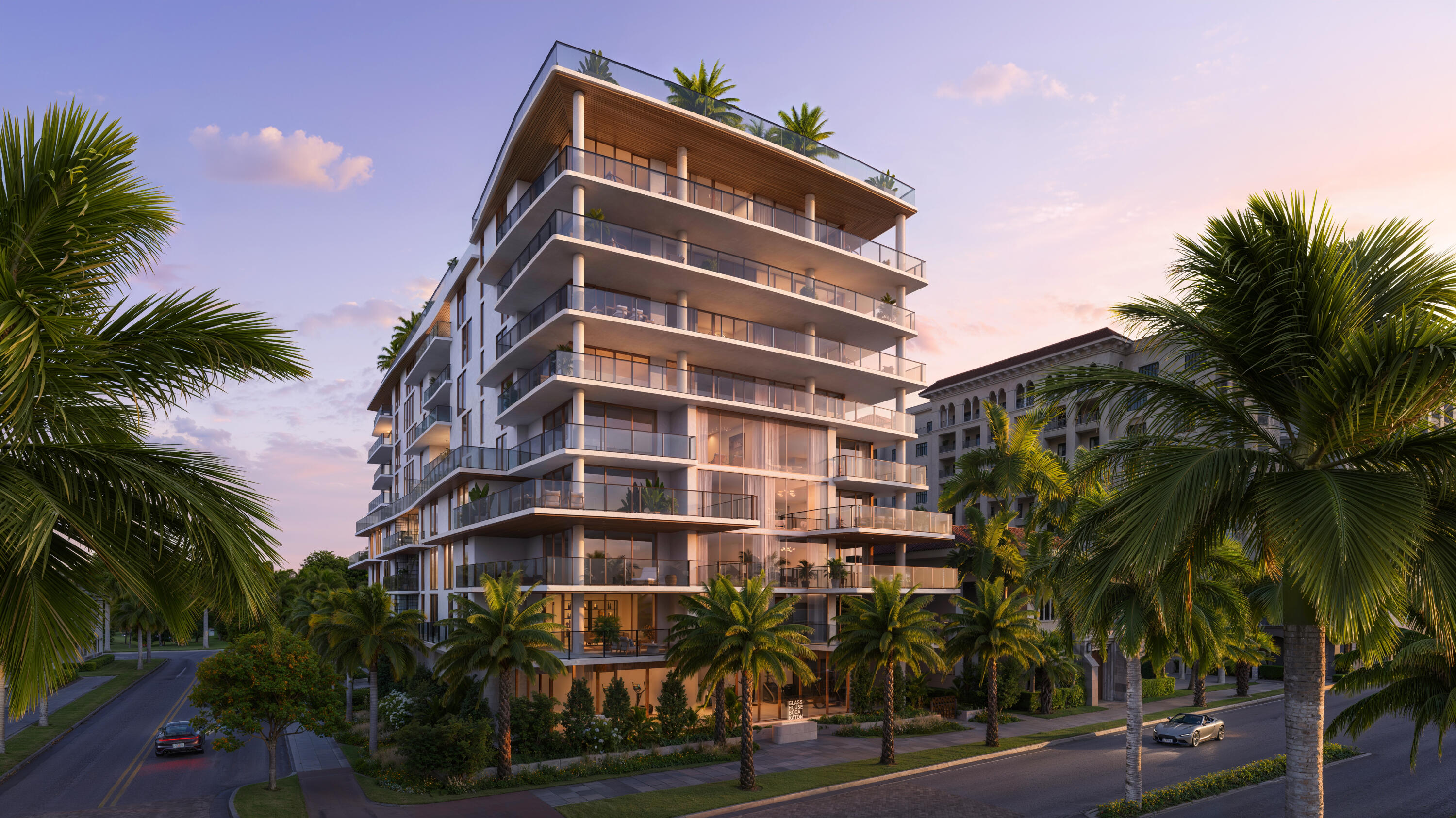 a front view of multi story residential apartment building with yard and parking space