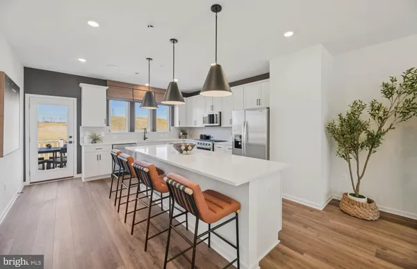 a kitchen with stainless steel appliances kitchen island a table and chairs in it