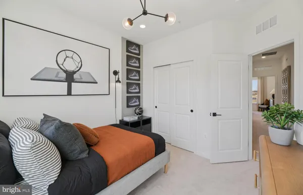 a bedroom with a bed and painting on the wall