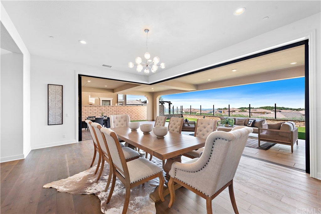 186 Leafy Pass Irvine, CA 92602 - Photo 11 of 59 a view of a dining room with furniture wooden floor and chandelier