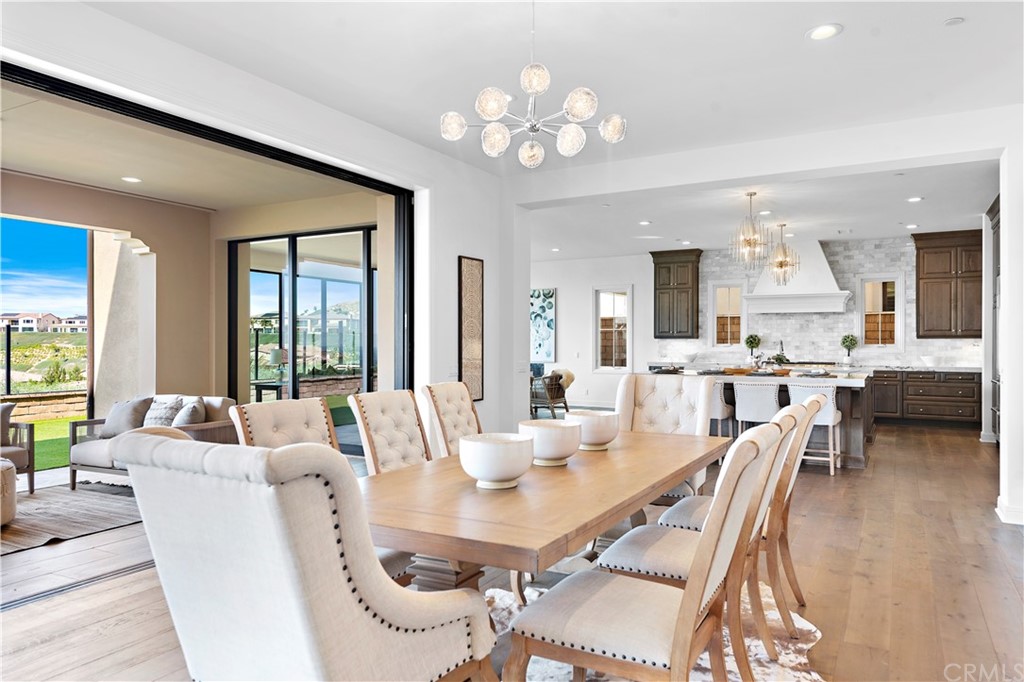 186 Leafy Pass Irvine, CA 92602 - Photo 12 of 59 a dining room with furniture a large window and wooden floor