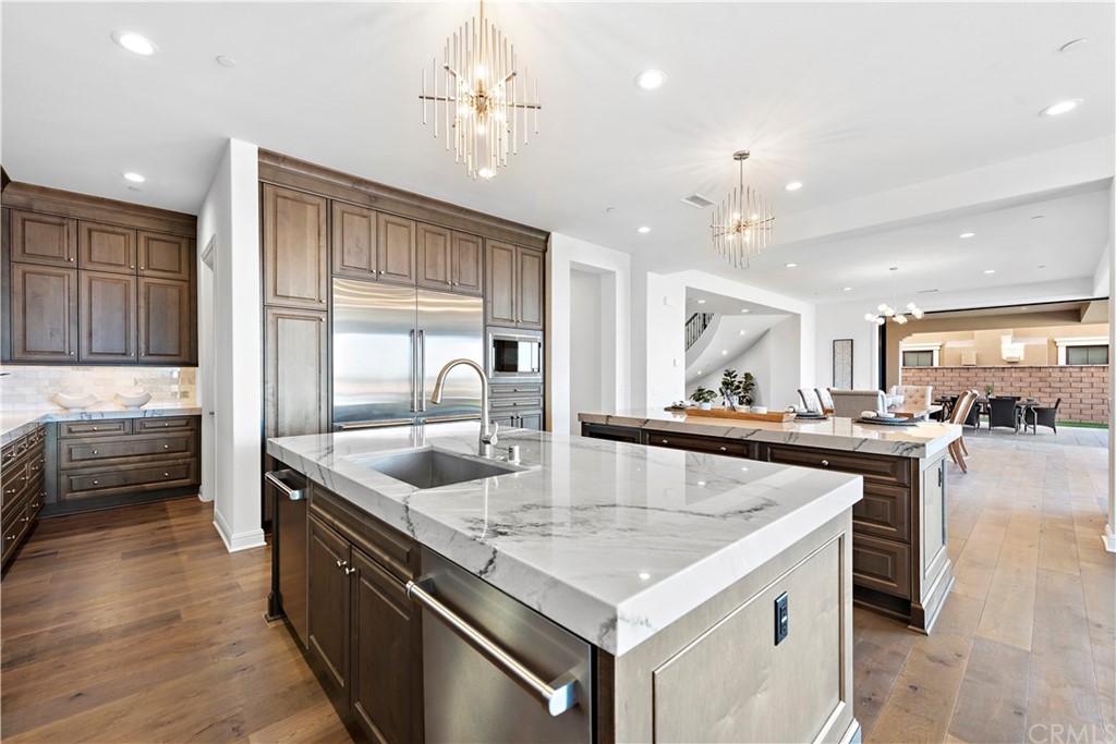 186 Leafy Pass Irvine, CA 92602 - Photo 22 of 59 a kitchen with stainless steel appliances granite countertop a sink a stove and a wooden cabinets