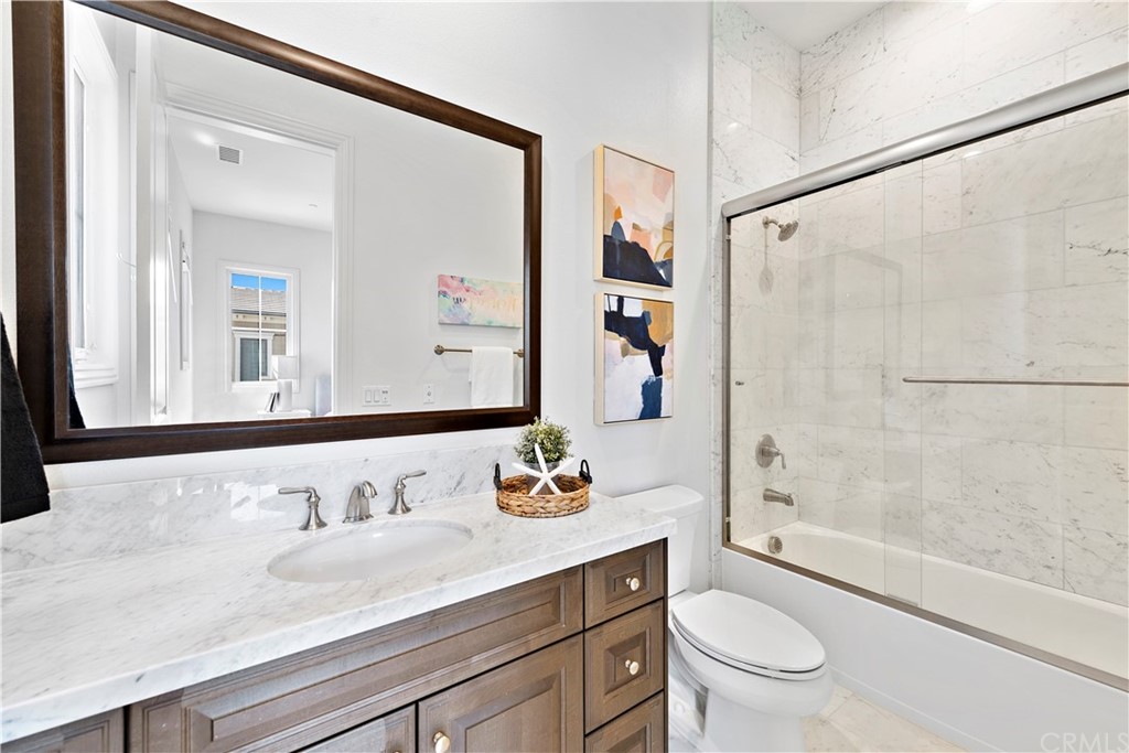 186 Leafy Pass Irvine, CA 92602 - Photo 42 of 59 a bathroom with a granite countertop sink toilet a mirror and shower