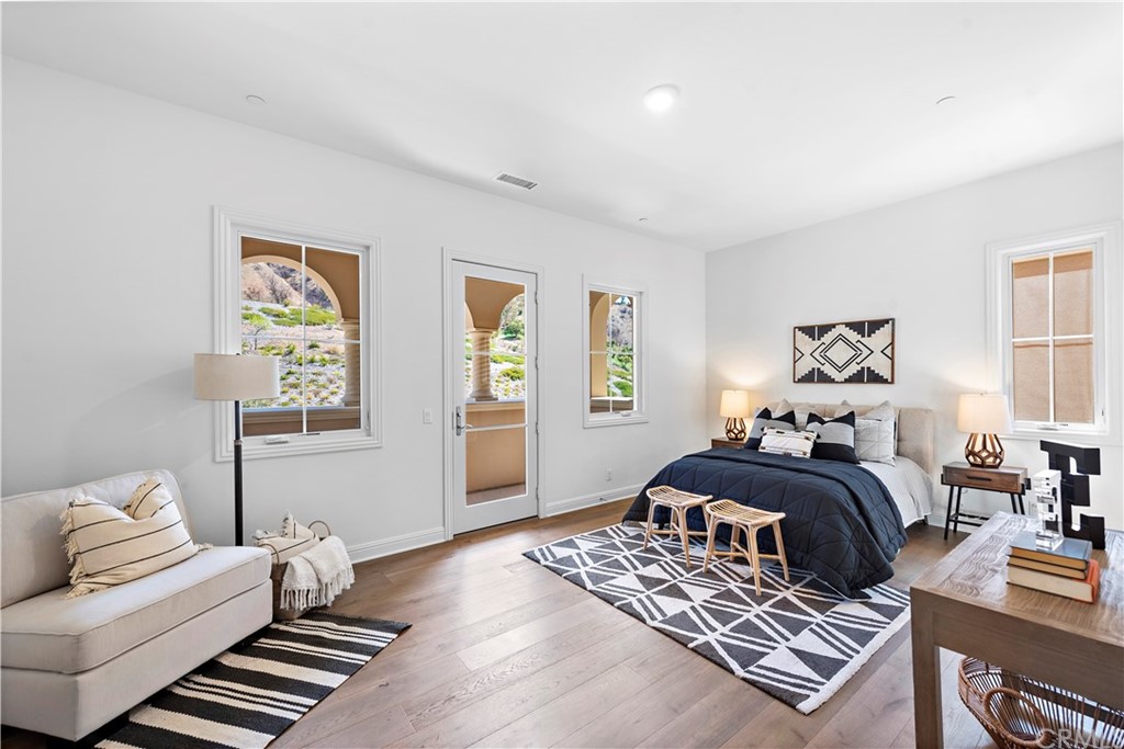 186 Leafy Pass Irvine, CA 92602 - Photo 45 of 59 a bedroom with a bed and wooden floor