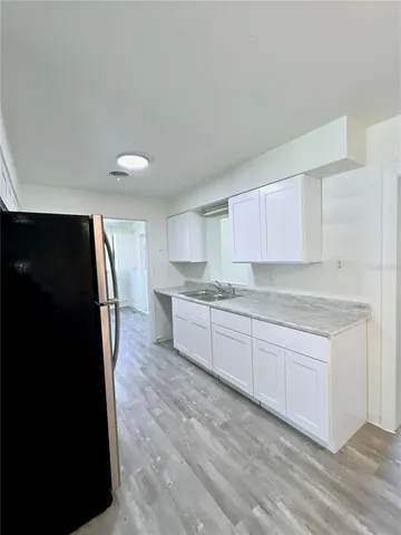 a kitchen with granite countertop a refrigerator and a sink