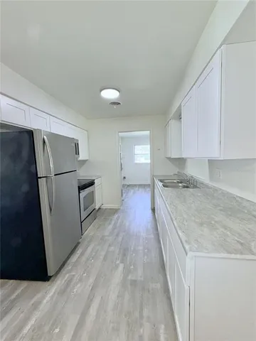 a kitchen with granite countertop a refrigerator a sink and dishwasher