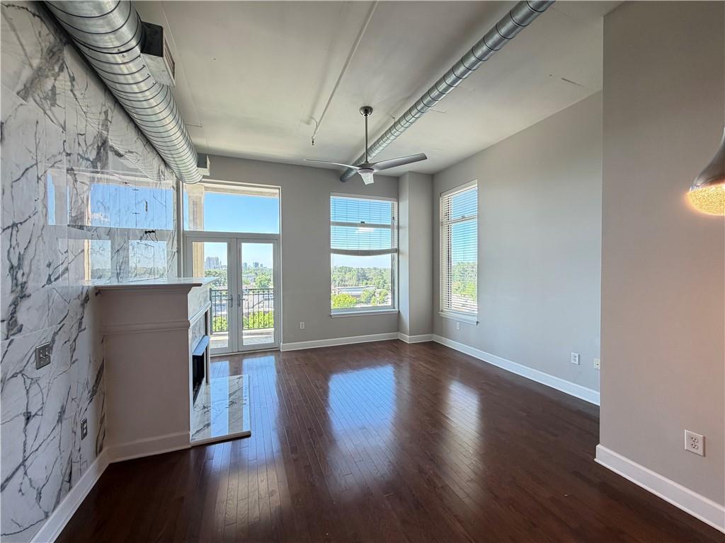 3820 Roswell Road Northeast, Unit 902 Atlanta, GA 30342 - Photo 4 of 20 a view of an empty room with wooden floor and a window