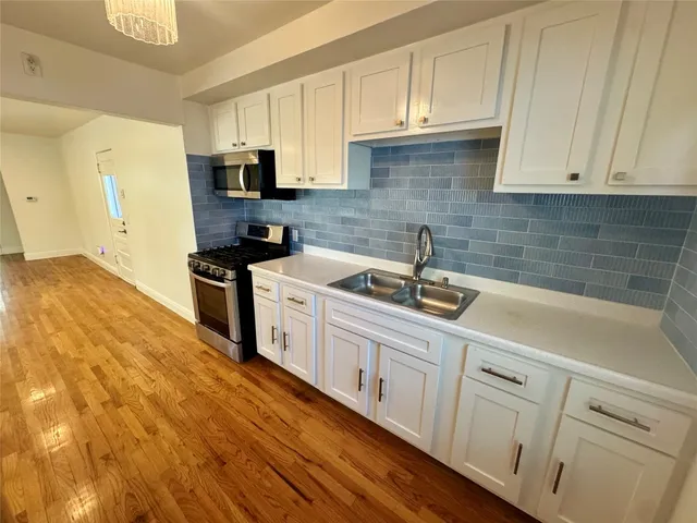 a kitchen with white cabinets sink and stainless steel appliances