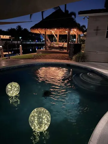 a living room with furniture and a dining table with kitchen appliances