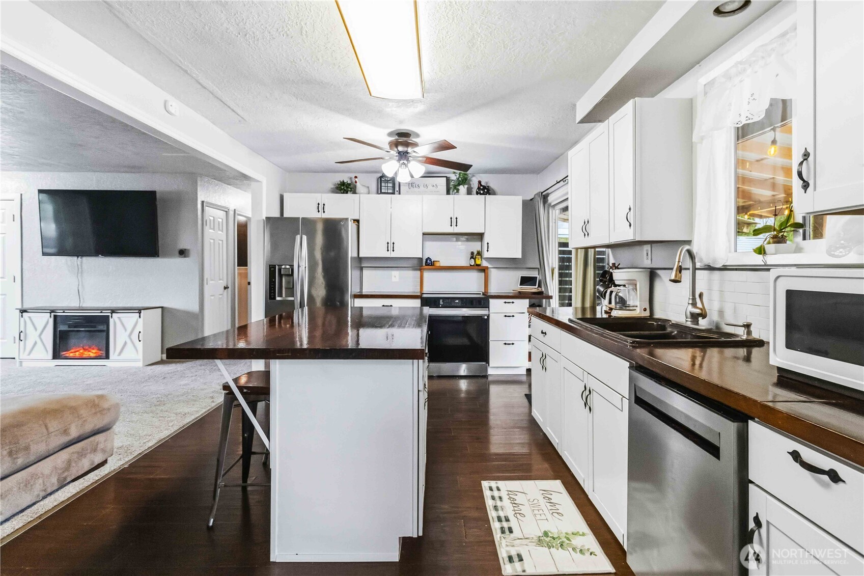 2323 48th Avenue Longview, WA 98632 - Photo 6 of 18 a kitchen with stainless steel appliances kitchen island granite countertop a stove top oven a sink a counter space and cabinets