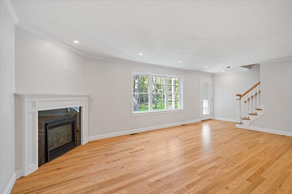 509 Mendon Road, Unit 509 Attleboro, MA 02703 - Photo 11 of 31 an empty room with wooden floor fireplace and windows