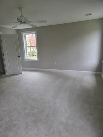 a spacious bedroom with a large bed and a window