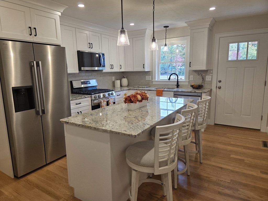 509 Mendon Road, Unit 509 Attleboro, MA 02703 - Photo 4 of 31 a kitchen with stainless steel appliances granite countertop a table chairs stove microwave and refrigerator