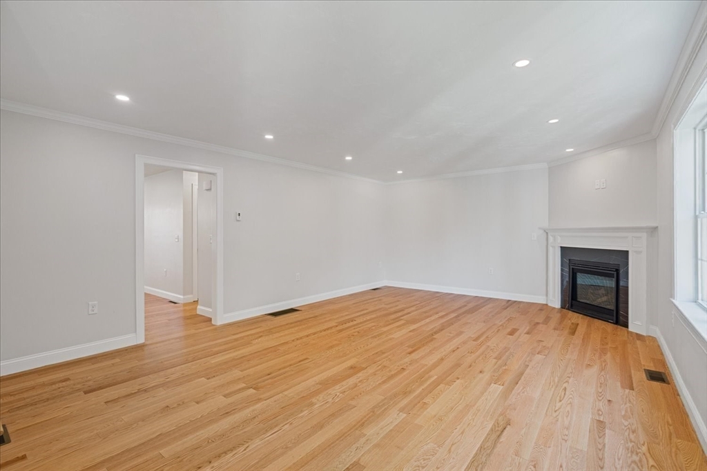 509 Mendon Road, Unit 509 Attleboro, MA 02703 - Photo 9 of 31 a view of empty room with wooden floor and fireplace