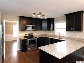 3526 High Ridge Road Charlotte, NC 28270 - Photo 5 of 16 a kitchen with granite countertop a stove top oven a sink dishwasher and a microwave oven with wooden floor