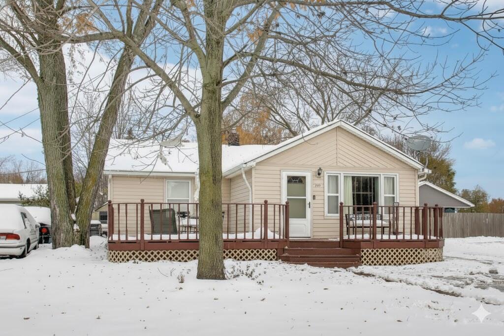 a front view of a house with a yard covered in snow