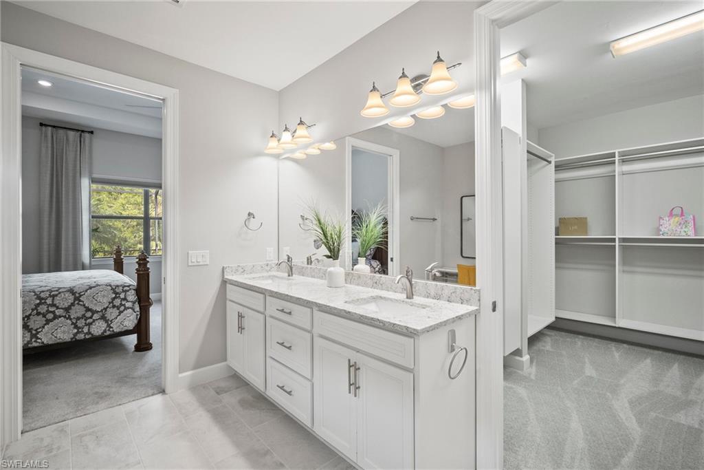 14227 Wild Timber Court Estero, FL 33928 - Photo 17 of 49 a spacious bathroom with a granite countertop sink a light fixture and a mirror