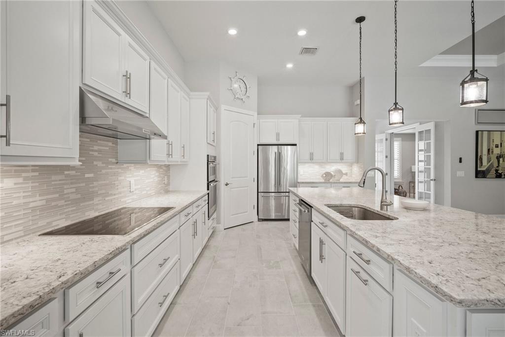 14227 Wild Timber Court Estero, FL 33928 - Photo 30 of 49 a large kitchen with kitchen island granite countertop a large counter top a sink stainless steel appliances and cabinets