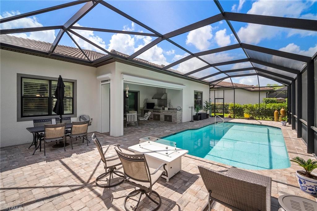 14227 Wild Timber Court Estero, FL 33928 - Photo 39 of 49 a view of a patio with table and chairs under an umbrella