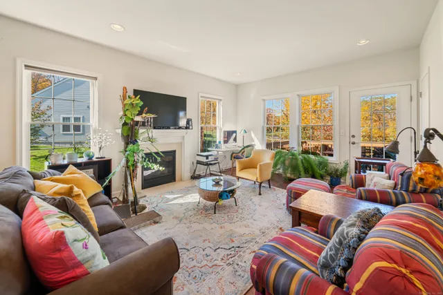a living room with furniture fireplace and a large window