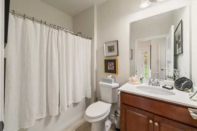 a bathroom with a sink a toilet a mirror and shower curtain