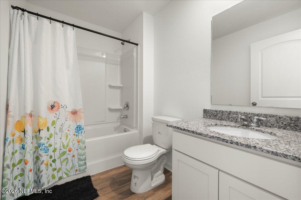 671 Live Oak Loop Crescent City, FL 32112 - Photo 12 of 38 a bathroom with a granite countertop sink a toilet and shower
