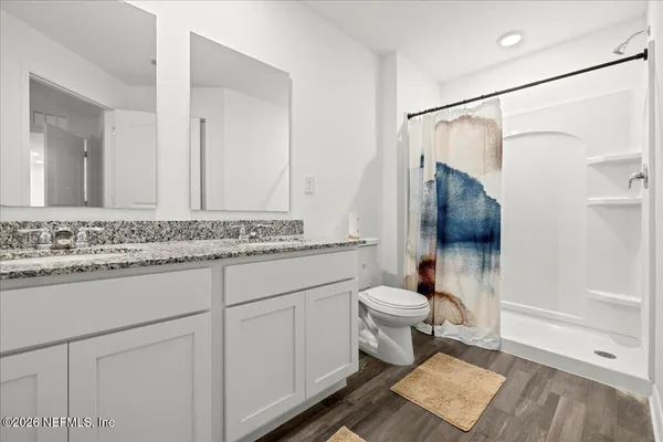 a bathroom with a sink toilet a mirror and shower