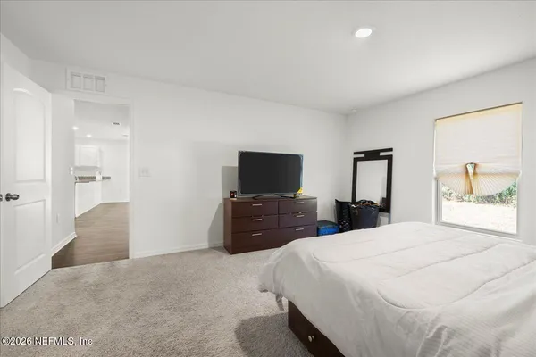 a bedroom with a bed and a flat screen tv