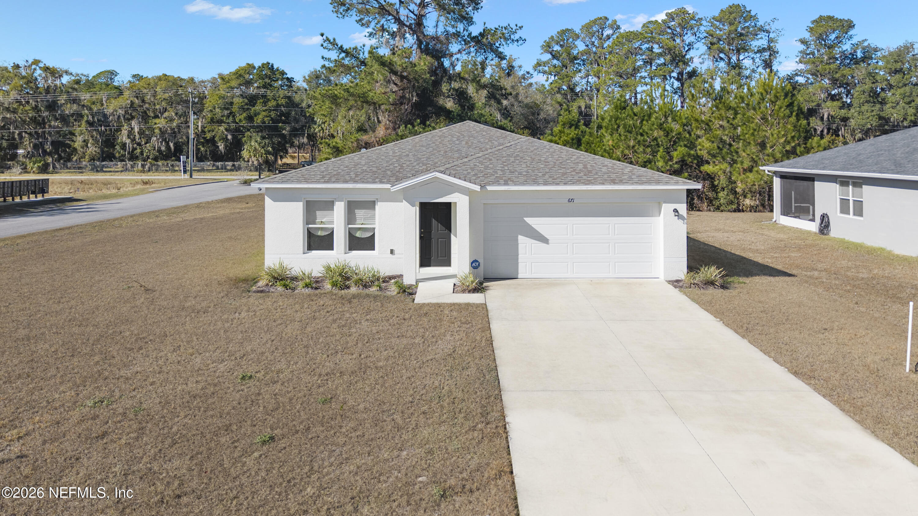 671 Live Oak Loop Crescent City, FL 32112 - Photo 2 of 38 a front view of a house with a yard and garage