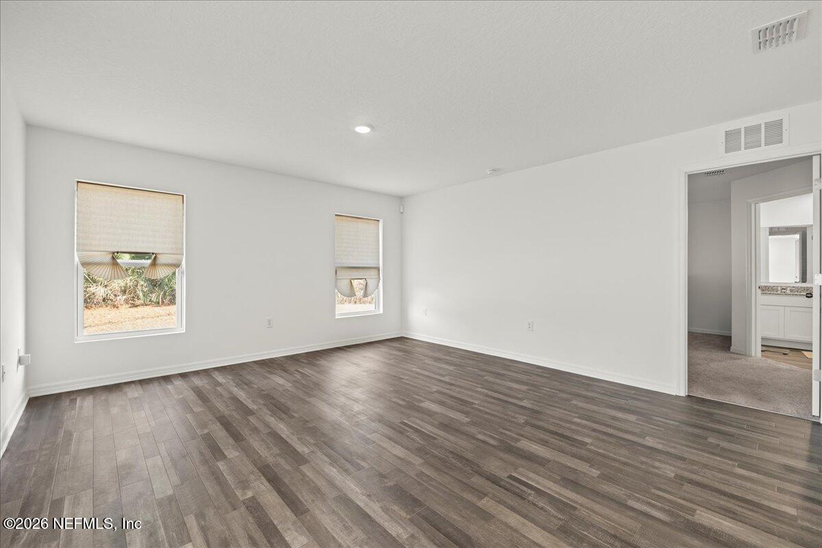 671 Live Oak Loop Crescent City, FL 32112 - Photo 21 of 38 an empty room with wooden floor and windows