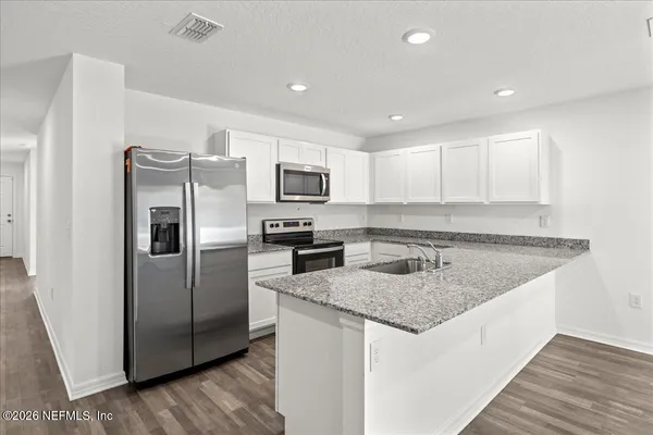 a kitchen with stainless steel appliances granite countertop a refrigerator a sink a stove a microwave and island