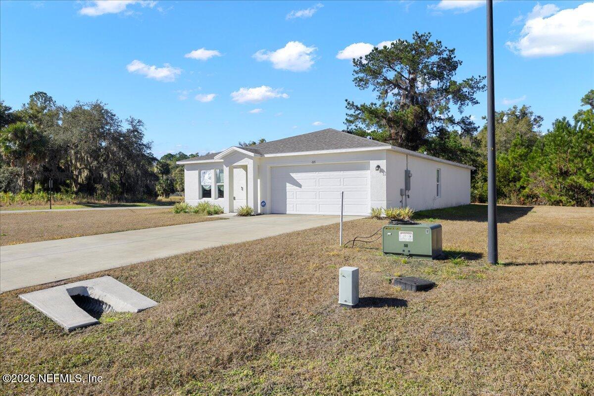 671 Live Oak Loop Crescent City, FL 32112 - Photo 7 of 38 a front view of a house with a yard and garage