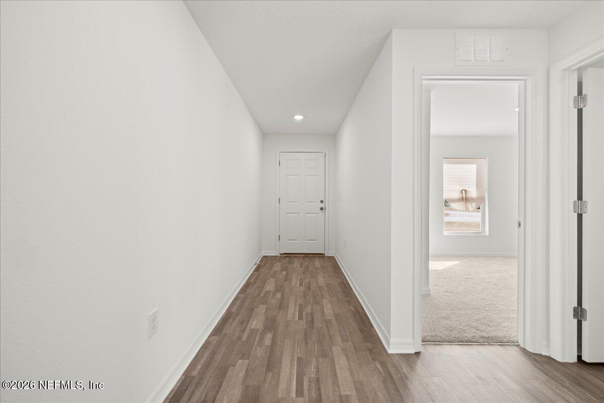 671 Live Oak Loop Crescent City, FL 32112 - Photo 9 of 38 a view of a hallway with wooden floor and a bathroom
