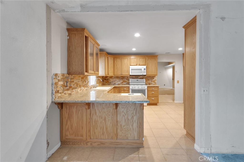 13934 Okesa Road Apple Valley, CA 92307 - Photo 11 of 34 a kitchen with kitchen island cabinets and refrigerator