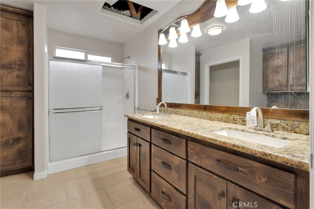 13934 Okesa Road Apple Valley, CA 92307 - Photo 23 of 34 a bathroom with a granite countertop sink and a mirror