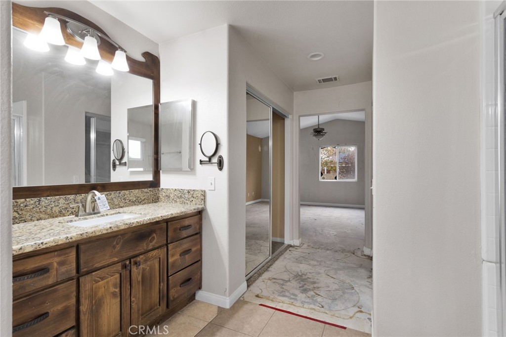 13934 Okesa Road Apple Valley, CA 92307 - Photo 27 of 34 a bathroom with a granite countertop sink mirror and a shower