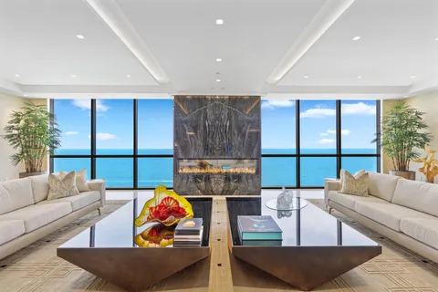 a living room with furniture kitchen view and a large window