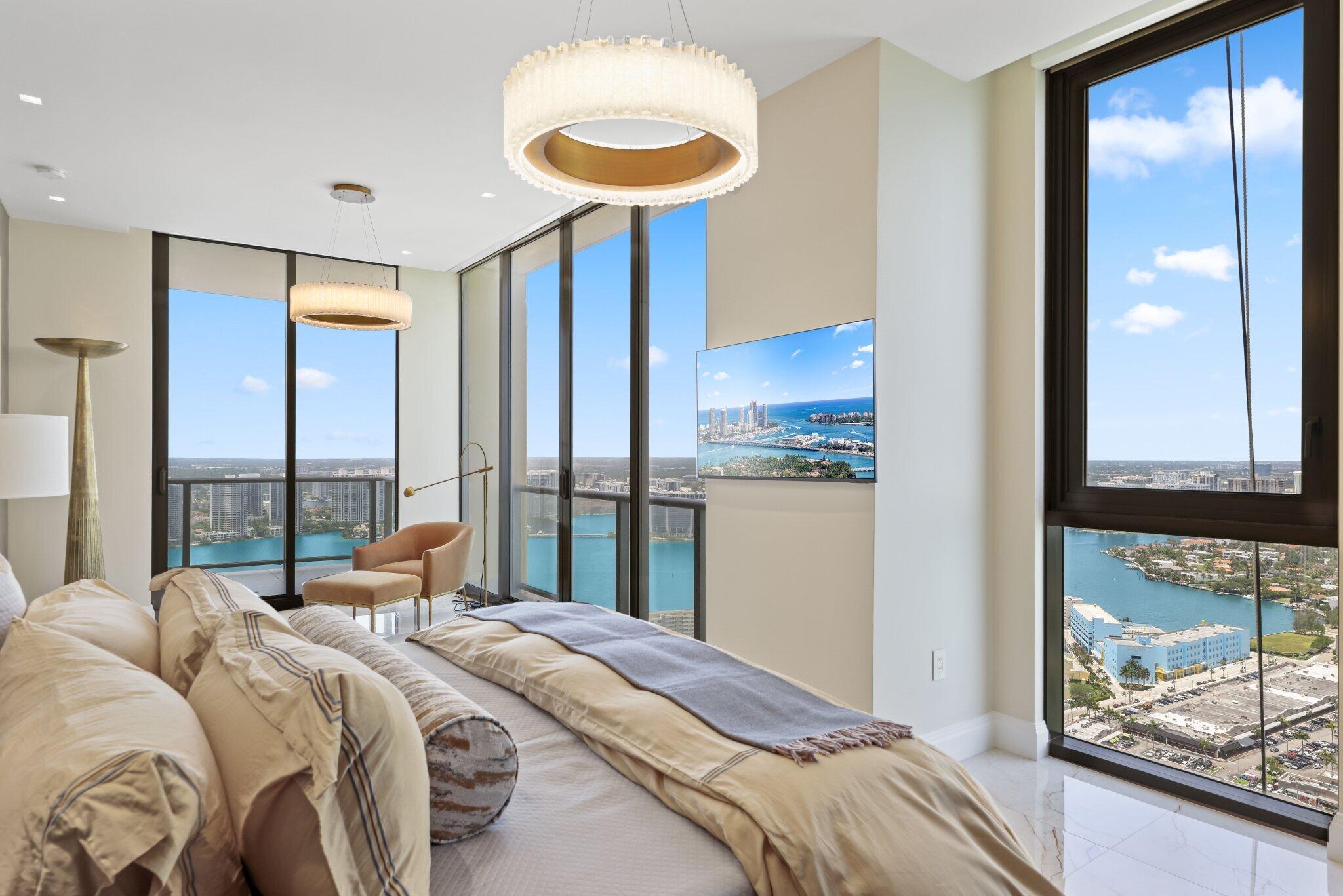 17749 Collins Avenue, Unit TS 3901/3902 Sunny Isles Beach, FL 33160 - Photo 53 of 127 a bedroom with a bed and a chandelier