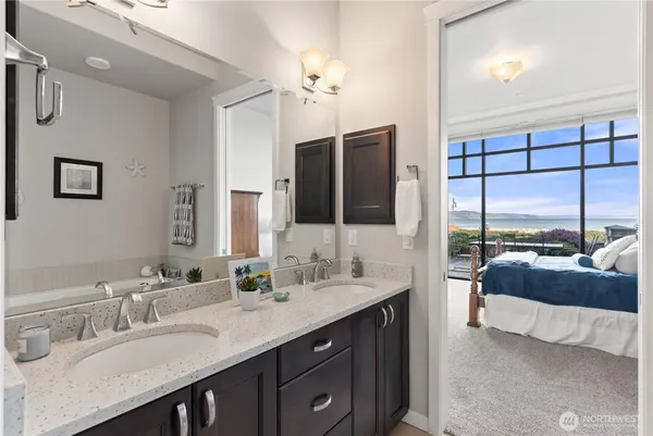 a spacious bathroom with a double vanity sink a large mirror and a bathtub