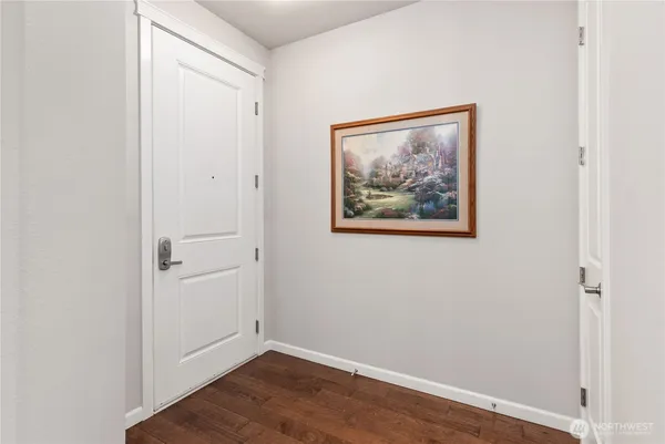 an empty room with wooden floor and painting on the wall