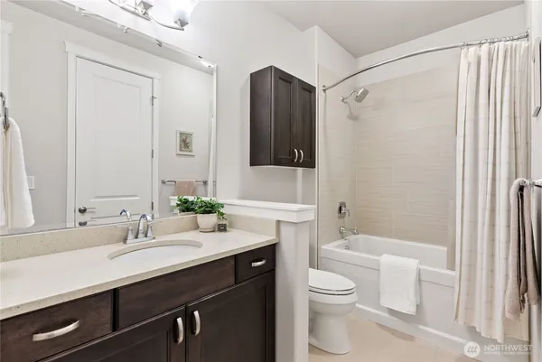 a bathroom with a double vanity sink toilet and shower