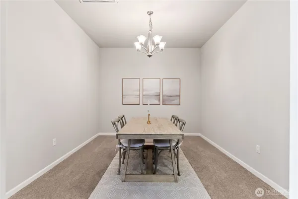 a dining room with chandelier and a window