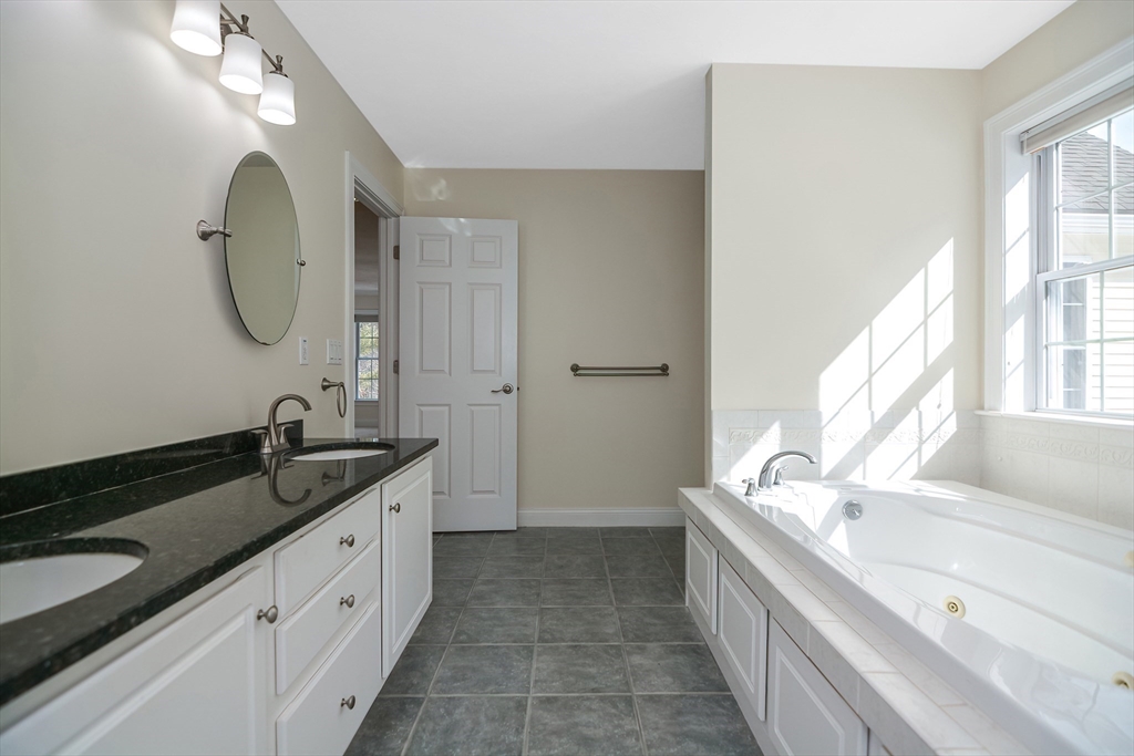 268 Hall Street Dunstable, MA 01827 - Photo 17 of 36 a spacious bathroom with a granite countertop double vanity sink a mirror and a bathtub