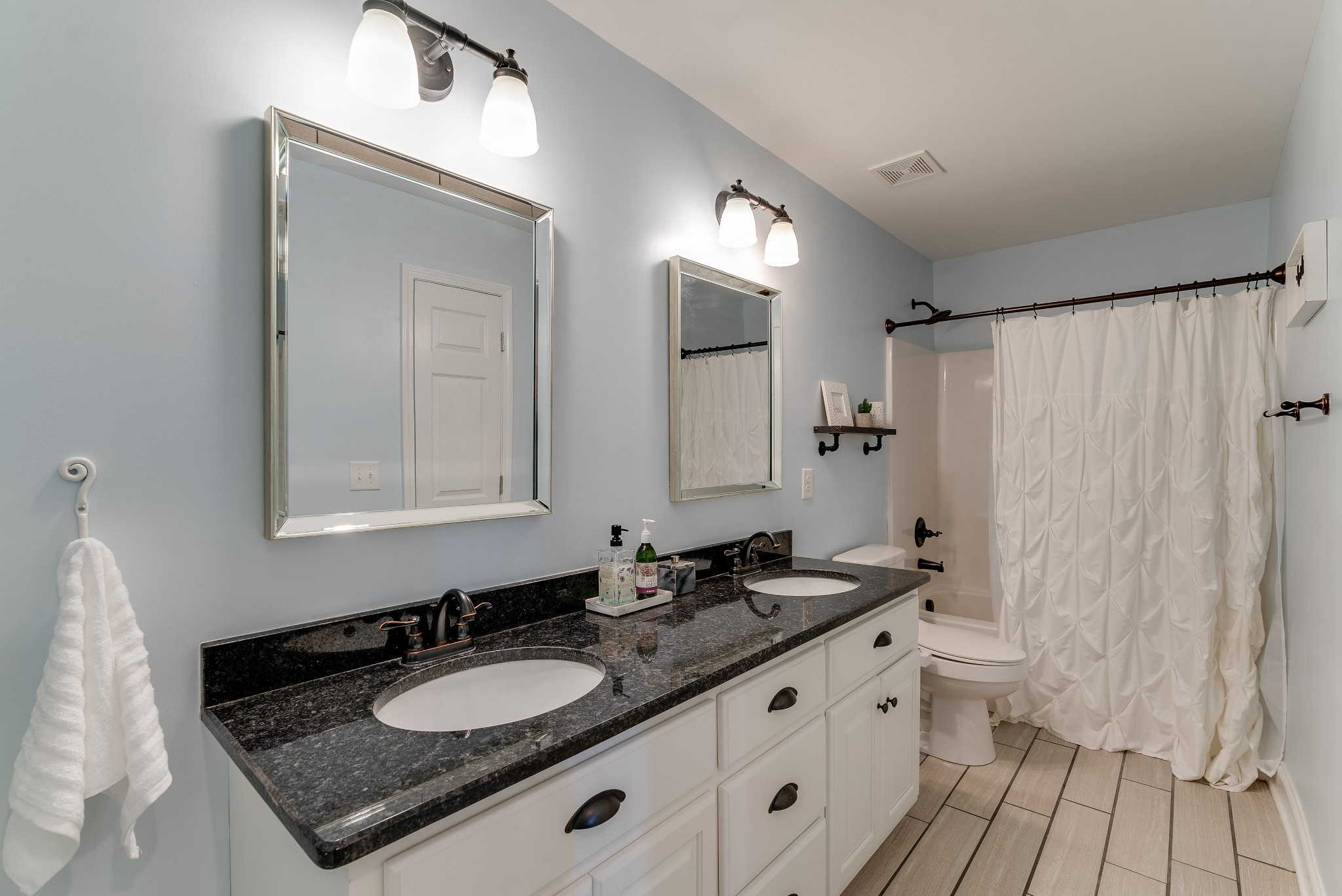 1117 Rip Steele Road Columbia, TN 38401 - Photo 20 of 35 a bathroom with a granite countertop sink a mirror a vanity and a shower