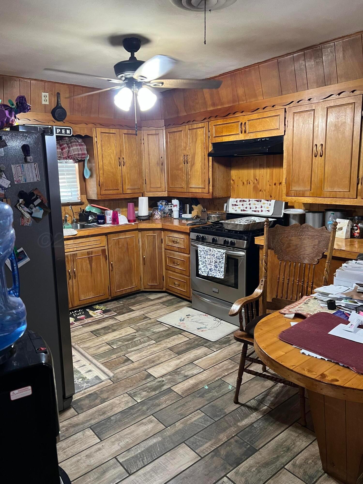 310 East 12th Street Friona, TX 79035 - Photo 3 of 10 a kitchen with stainless steel appliances granite countertop a stove refrigerator and cabinets