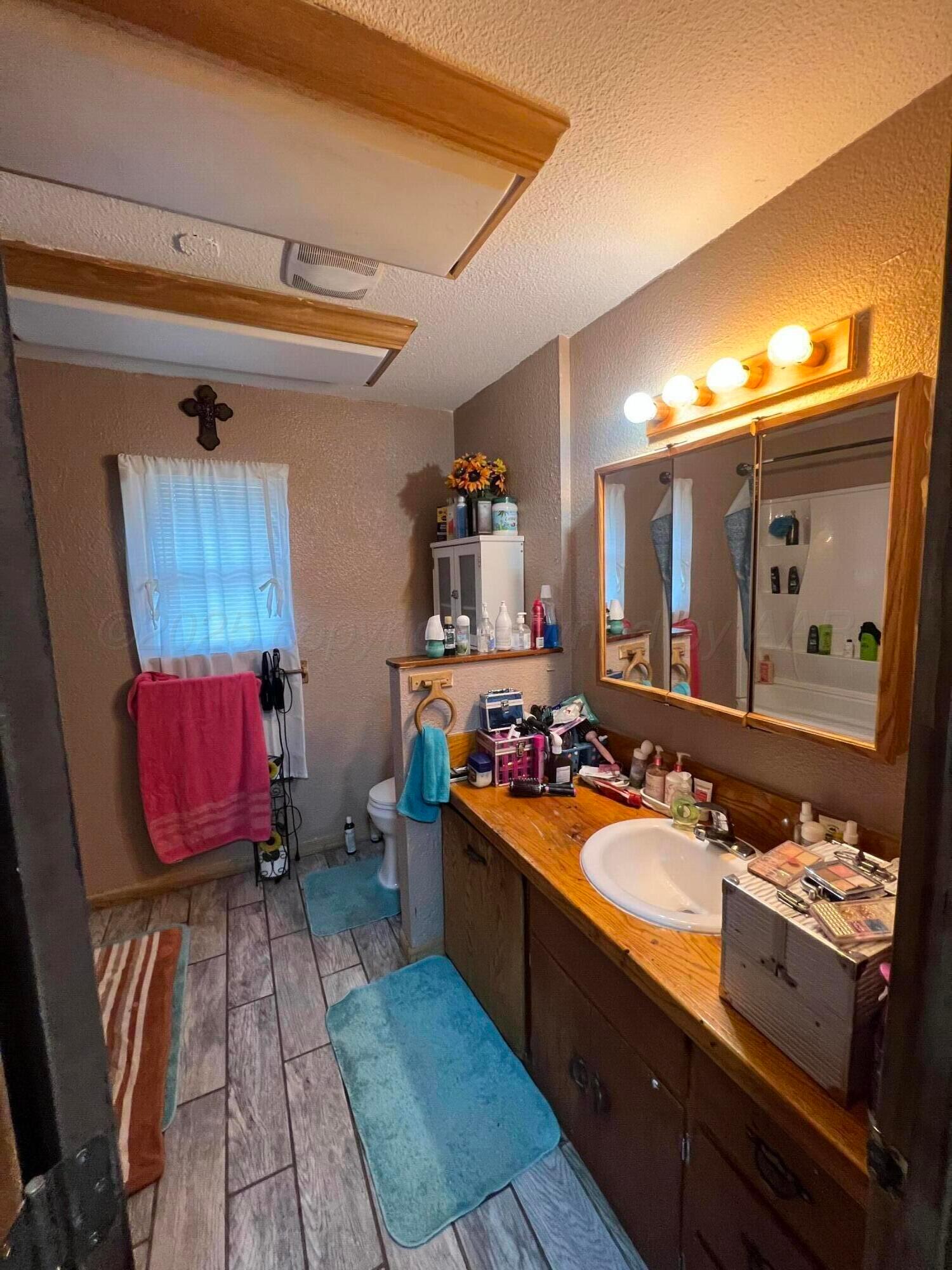 310 East 12th Street Friona, TX 79035 - Photo 6 of 10 a bathroom with a sink double vanity granite and a mirror