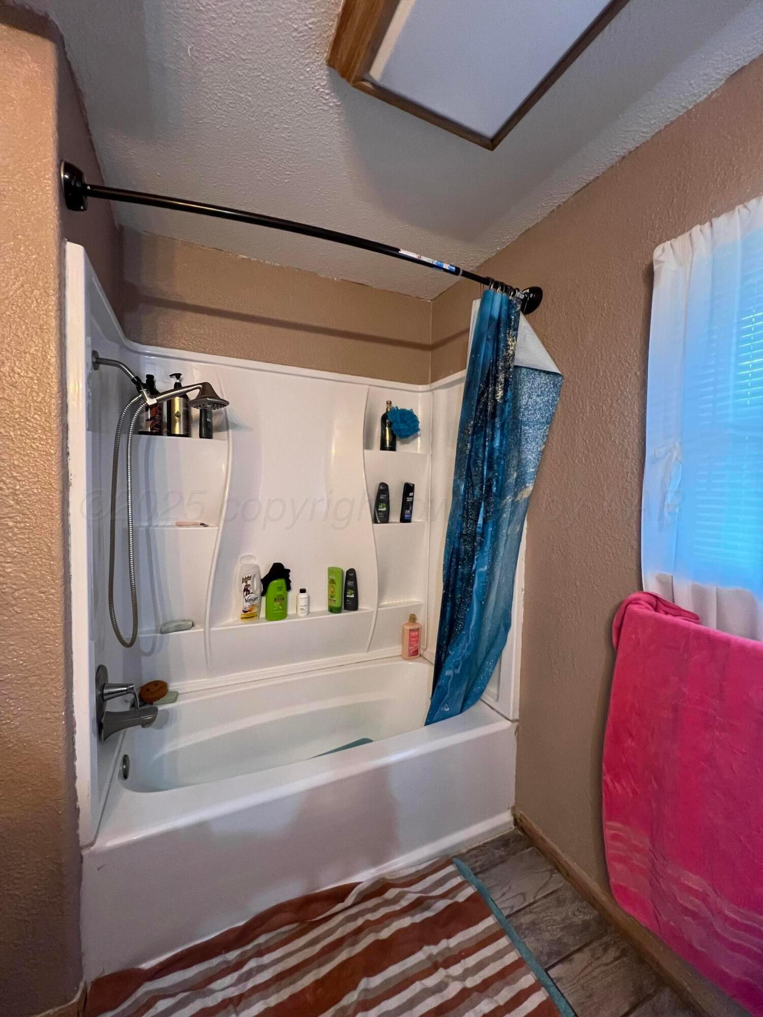 310 East 12th Street Friona, TX 79035 - Photo 7 of 10 a bathroom with a bathtub and shower