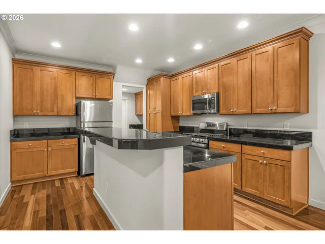 a kitchen with stainless steel appliances granite countertop a stove a sink dishwasher and a refrigerator