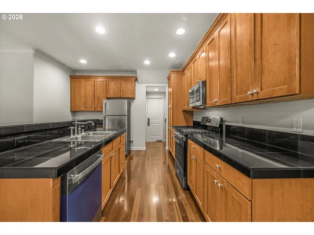 a kitchen with stainless steel appliances granite countertop a stove a sink and a microwave